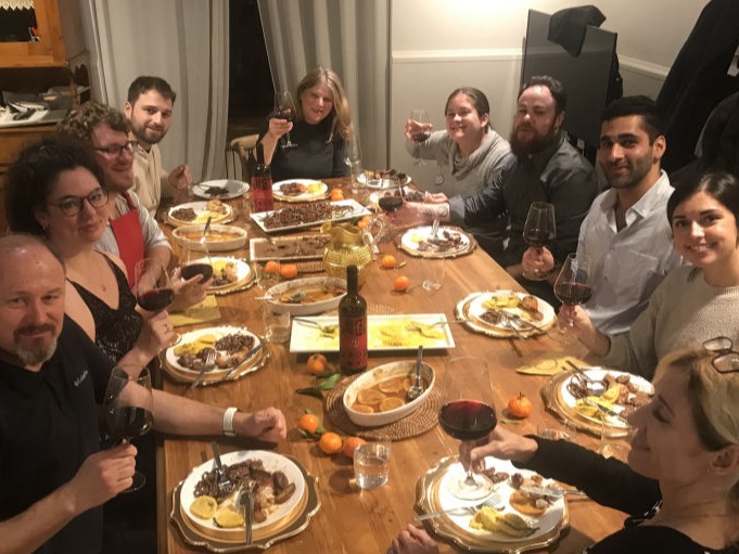 Dinner party guests toasting with wine over Italian feast