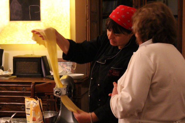 Chef teaching pasta making technique using pasta roller