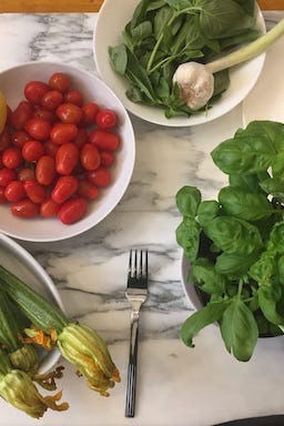 Fresh ingredients for Italian cooking - tomatoes, basil and garlic on marble counter